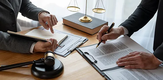 Team of legal professionals collaborating with documents and a gavel in a law office.