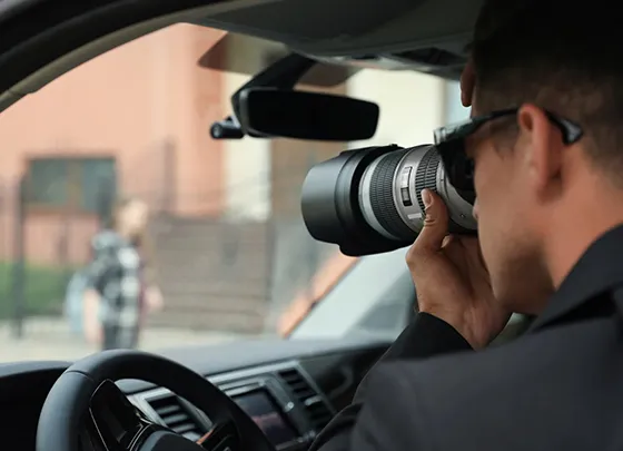 Professional private investigator in a car conducting surveillance.