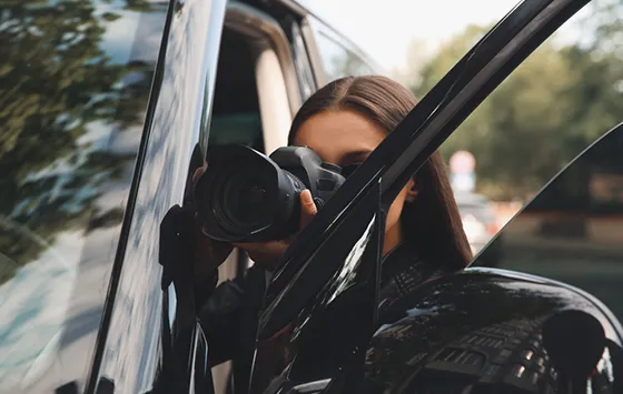 Private investigator with camera conducting surveillance in Red Bank, SC