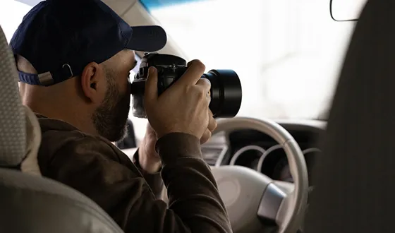 Private investigator taking photos from a car, showcasing investigative services in Hopkins, SC.
