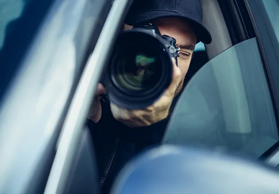 A private investigator using a camera from a car, symbolizing discreet investigative services in Gaston, SC.