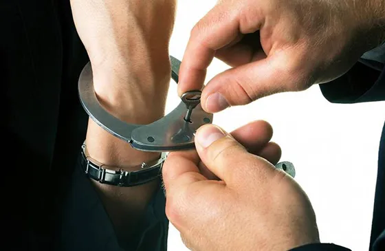 Hands of a person in handcuffs being assisted, representing trusted bail bond services in Red Bank, SC.
