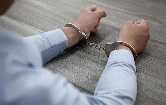 Person with hands in handcuffs representing the need for bail bonds services.