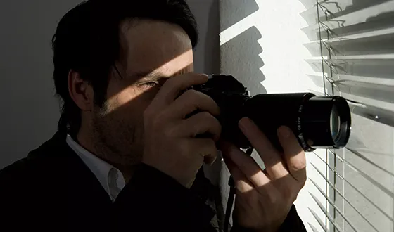 Top rated private investigator in Gaston, SC conducting surveillance with a camera.