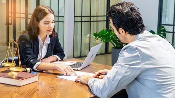 Two professionals discussing documents in a consultation meeting.